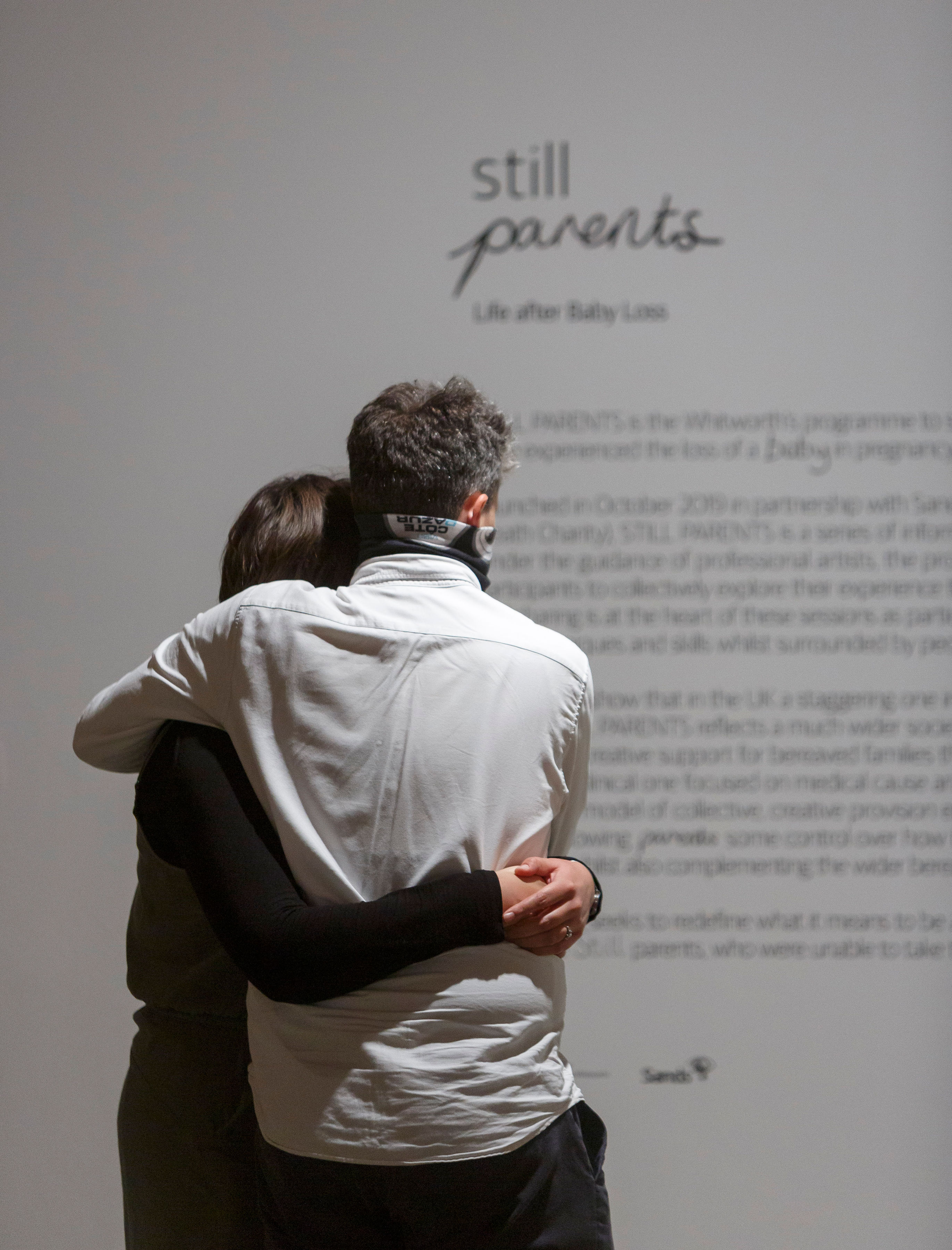 Photo of two parents holding each other after baby loss