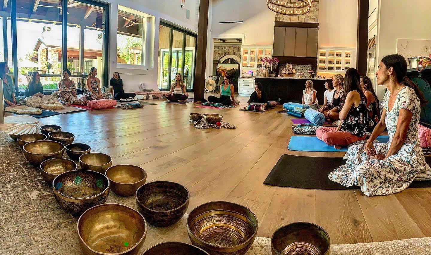 A group waits indoors for Stark to play singing bowls at a sound healing event.