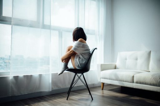 Young woman who attempted suicide looks out a window