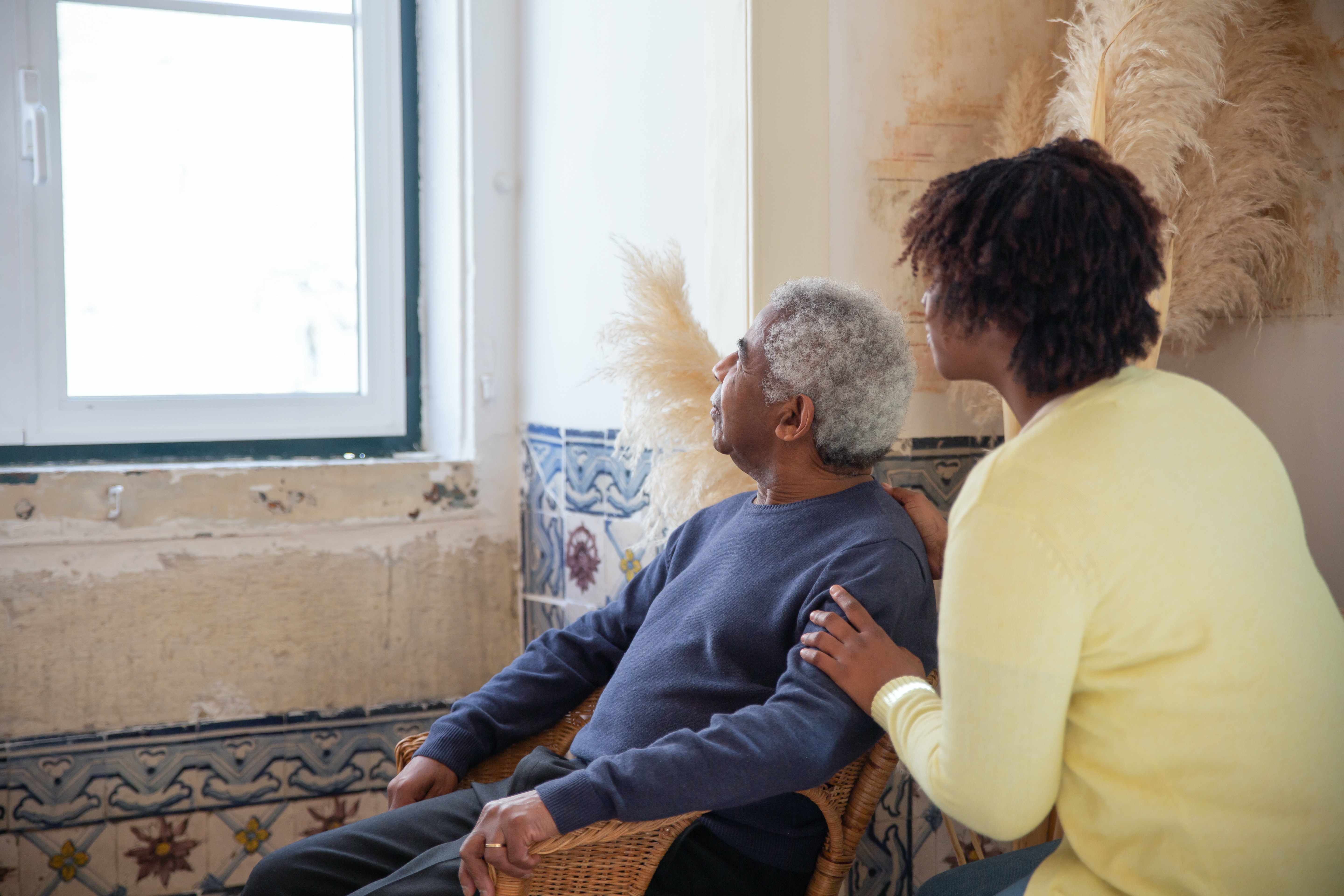 a man sits in a chair at home while receiving in-home care