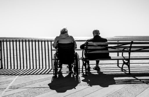 Two elderly men sit and look at the ocean, wondering if hospice misconceptions about length of life are true