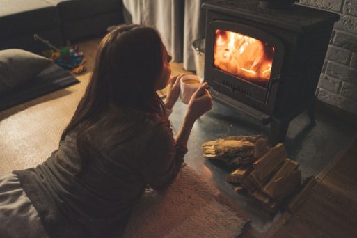 A woman stares into the fireplace, contemplating death during the holidays.