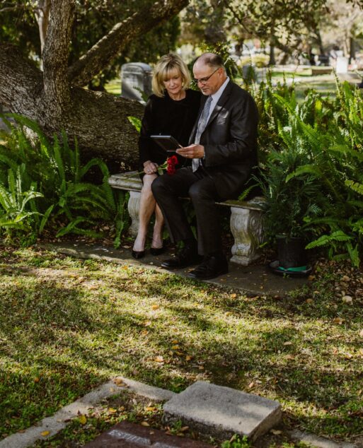 Man and woman grieving on bench at grave sight