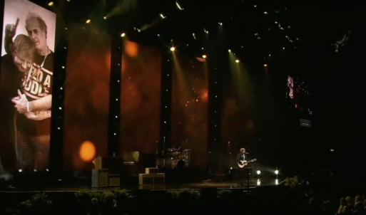 Ed Sheeran on stage singing "Visiting Hours" at memorial service