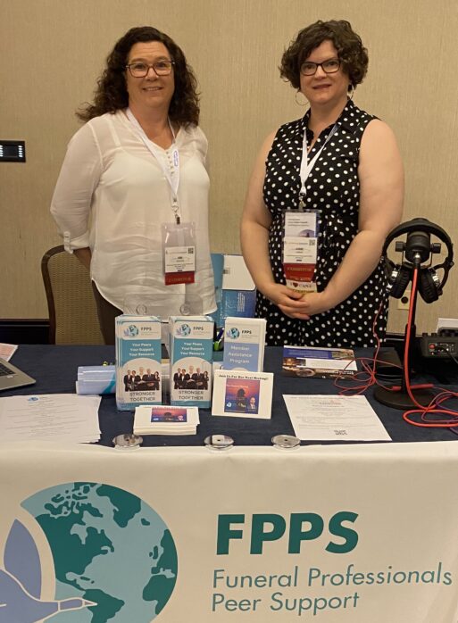 Kim Zavrosky and Anne Jaekel standing behind FPPS table display.