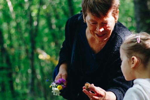A grandmother looks at treasures found on a walk with her grandchild.