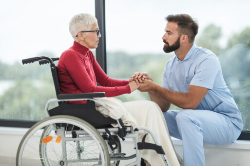 Old woman in wheelchair in hospital setting with doctor.