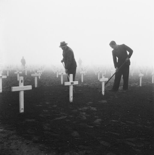 Two men in period clothing work together at the gravesite of Margraten in 1945