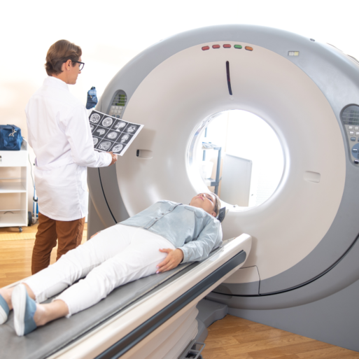 A woman prepares to get an MRI test performed, laying on the table that will shift into the large, circular portal