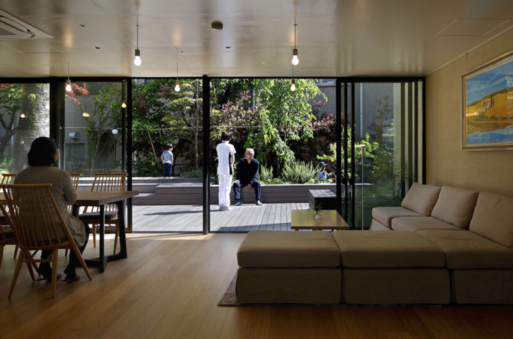 View from communal areal to outside deck where a man and woman are peaking. 