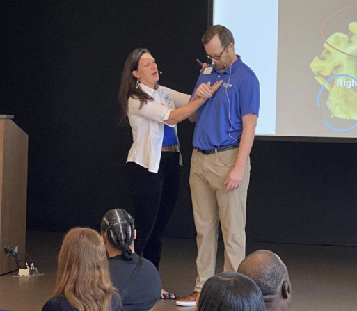 Amanda Bulgarelli and man onstage at a dementia care training.