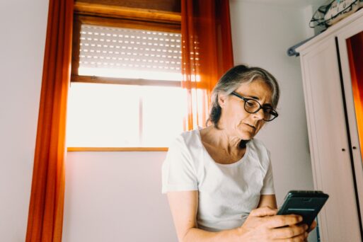 Older woman looking at phone to find end-of-life care.