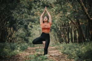 Woman in a forest in tree pose yoga stance