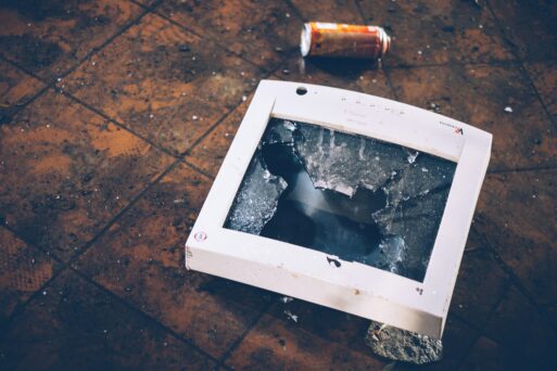 A computer with a smashed screen on the floor