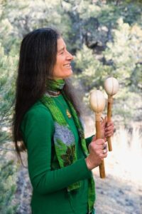 Author Sandra Ingerman engages in a practical application of "The Book of Ceremony" by shaking rattles.