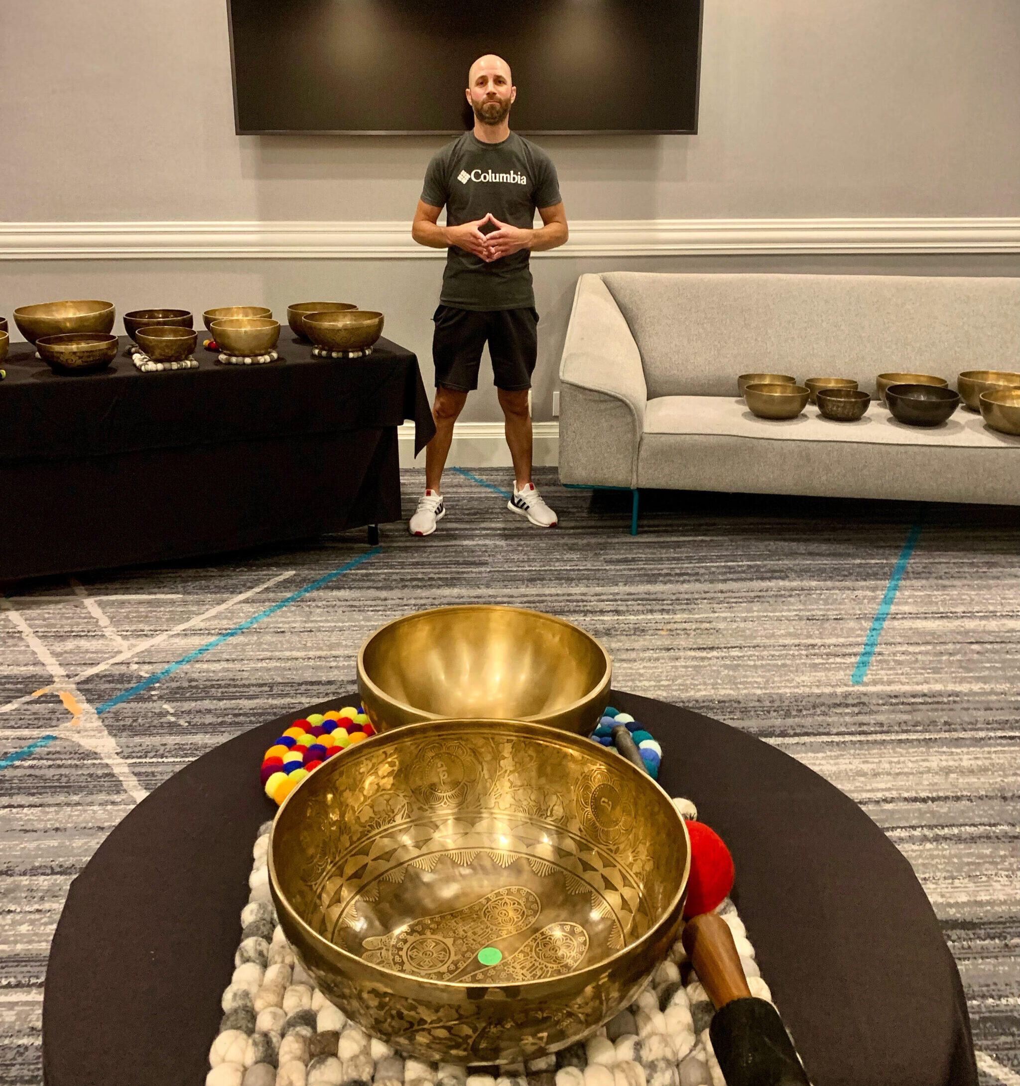 Jesse stark stands amid a collection of singing bowls.