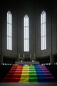 Church altar with LBGTQ+ flag draping the stairs