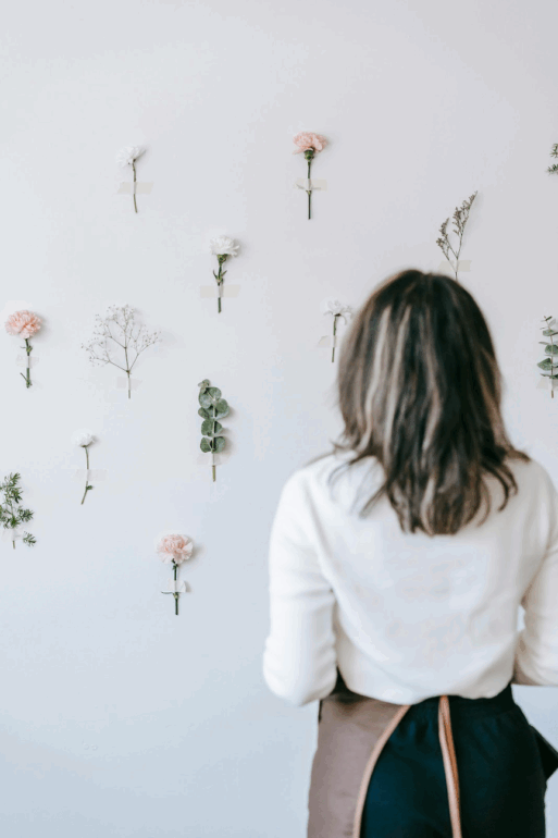 Fresh flower wall with a woman facing the wall.