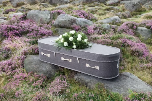Eco wool casket outdoors sitting on on rocks among flowers by natural legacy 