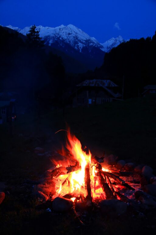 A campfire with mountains and stars reflecting 26 quotes as poetic symbols of life's end