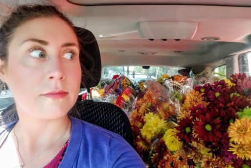Steffani sits in a van filled with flowers 