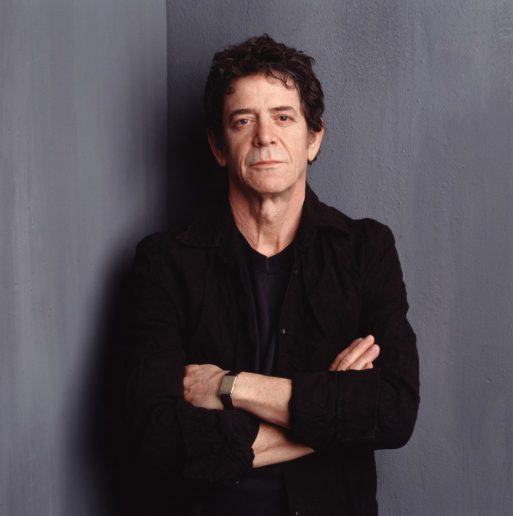 Photo of Lou Reed later in his life, wearing all black with his arms crossed