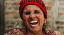 Laughing woman in red cap.