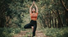 Woman in a forest in tree pose yoga stance